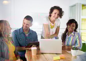 Multi ethnic group of succesful creative business people using a laptop during candid meeting-1
